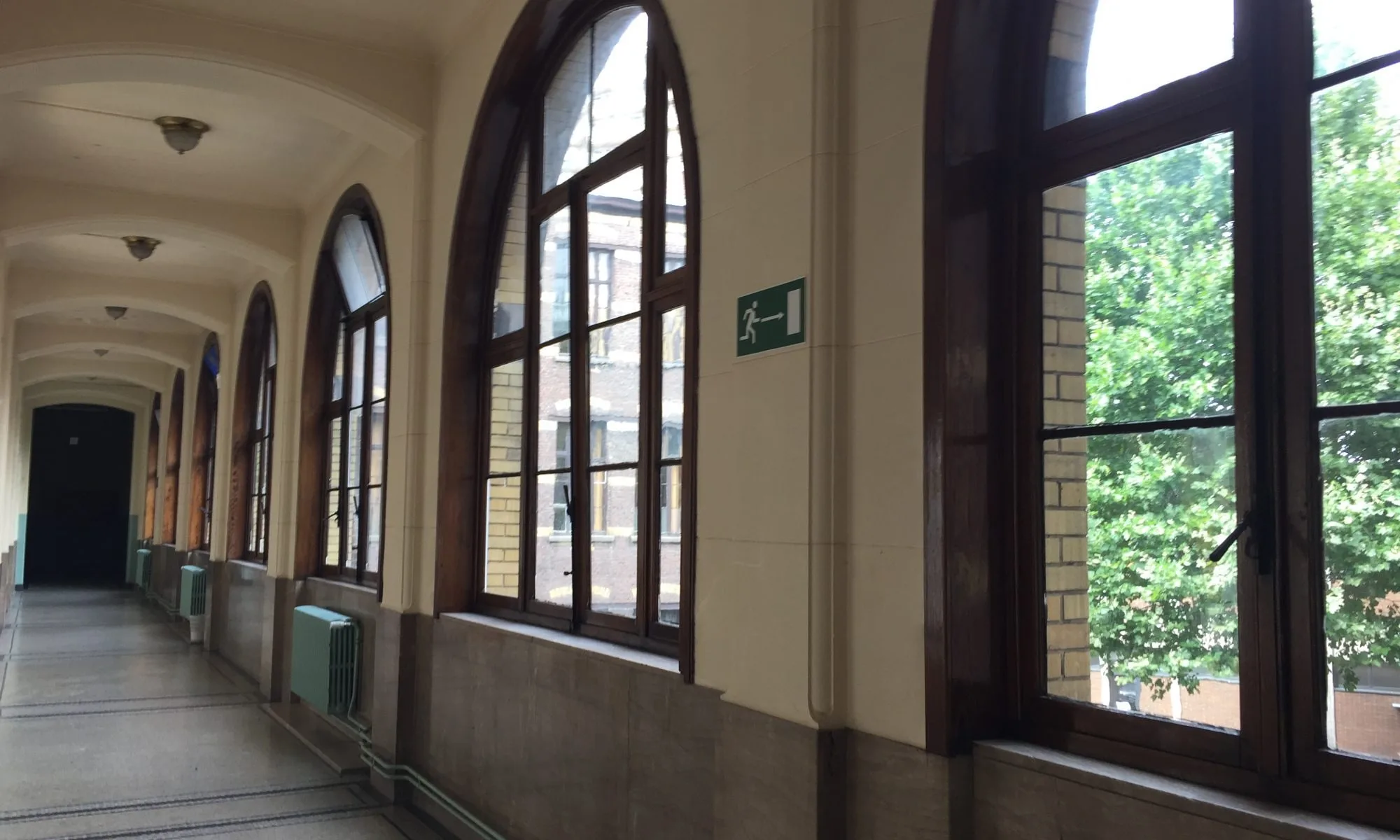 Couloir bordé de hautes fenêtres cintrées en bois, réalisées et posées par Delux-Châssis.